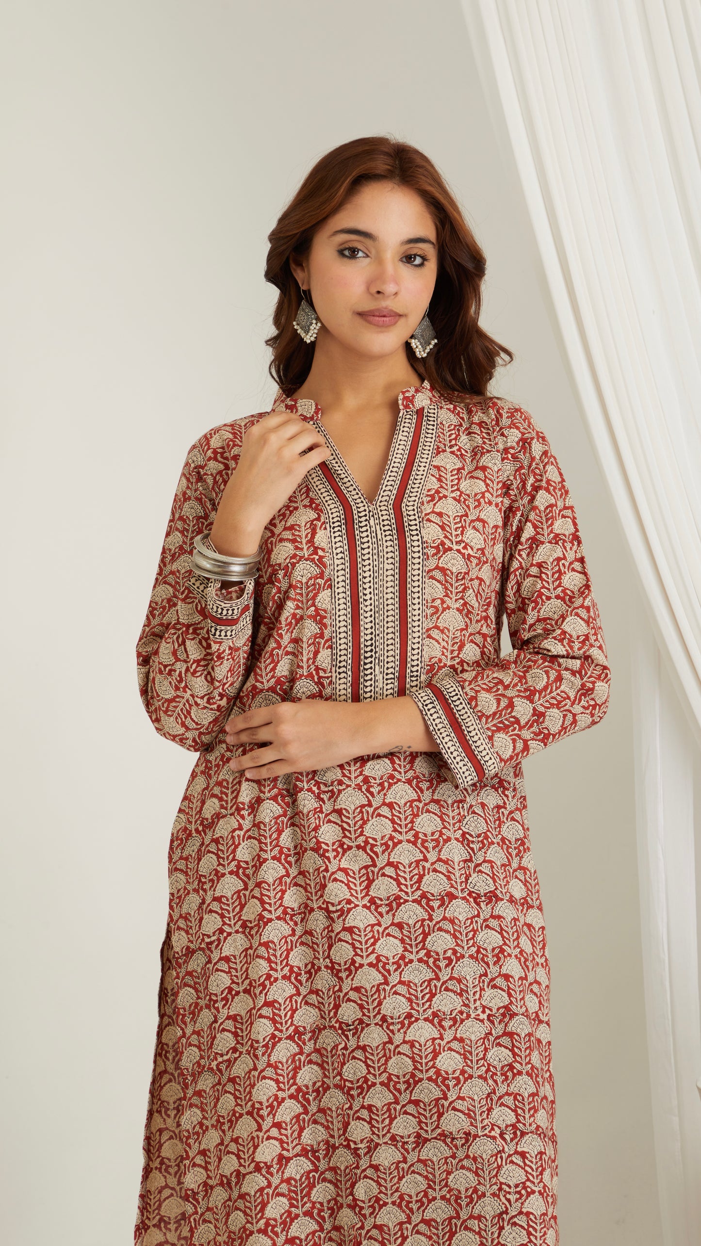 Detailed view of neckline and hand block print pattern on red cotton kurta